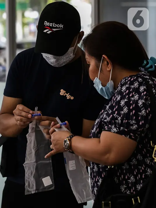 Calon penumpang kereta api melihat alat tes deteksi COVID-19 dengan metode GeNose C19 di stasiun Gambir, Jakarta, Senin (12/2/2021). Per hari ini, Stasiun Gambir mulai menerapkan layanan pemeriksaan GeNose C19 untuk penumpang yang hendak berpergian keluar kota (Liputan6.com/Johan Tallo)