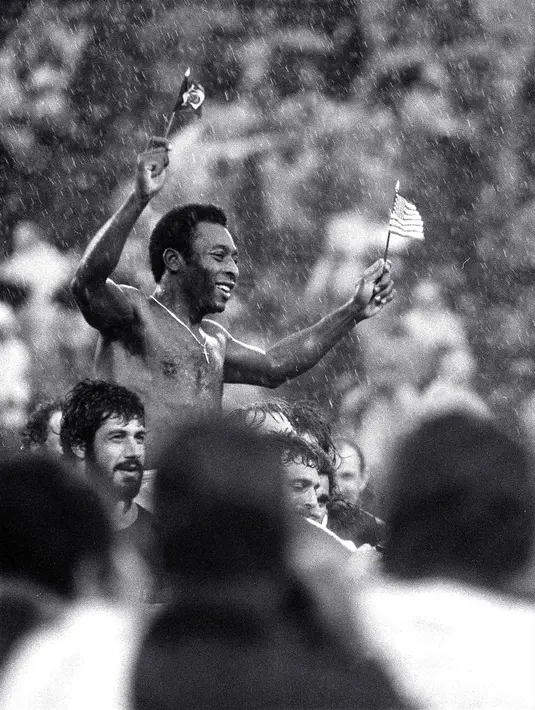 <p>Pemain sepak bola Brasil Edson Arantes do Nascimento atau Pele mengibarkan bendera Brasil dan AS saat dibawa keluar lapangan setelah pertandingan terakhirnya di Stadion Giants, East Rutherford, New Jersey, Amerika Serikat, 1 Oktober 1977. Pada akhir 1970-an, Pele bermain di Amerika Serikat untuk New York Cosmos sebelum akhirnya pensiun pada 1977. (AP Photo/Richard Drew, File)</p>