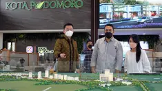 General Manager Marketing Kota Podomoro Tenjo Yoga Gunawan (kiri) berbincang dengan calon konsumen di depan maket Kota Podomoro Tenjo, di sela-sela peluncuran Klaster Kaliandra Kota Podomoro Tenjo, Bogor, Jawa Barat, (26/2/2022). (Liputan6.com/HO/Ading)