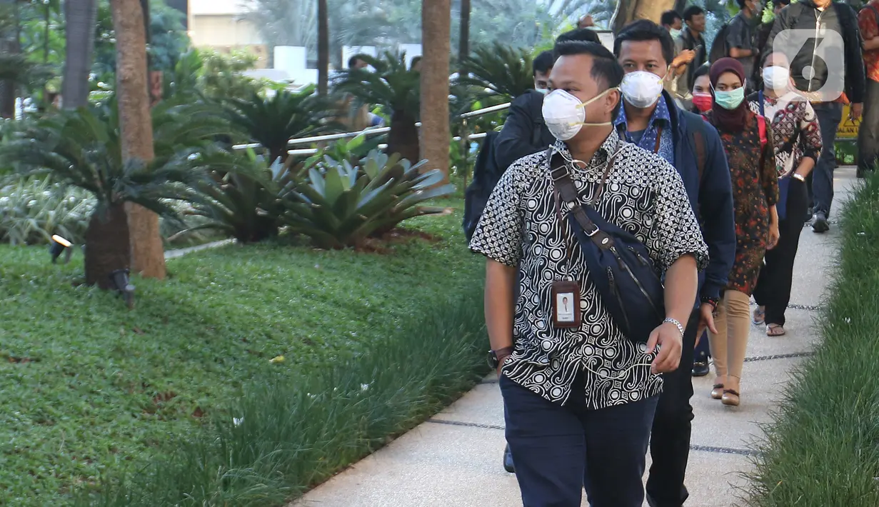Sejumlah karyawan menggunakan masker saat keluar dari gedung kantor Bank BRI, Jakarta, Kamis (23/1/2020). Menkes Terawan menegaskan tidak ada virus corona seperti info yang beredar sebelumnya. (Liputan6.com/Herman Zakharia)