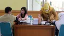 Petugas memeriksa kesehatan warga yang menjalani vaksinasi booster kedua atau dosis keempat di kawasan Kantor Wali Kota Jakarta Timur, Jakarta, Selasa (24/1/2023). Pelaksanaan booster kedua coba dipermudah oleh Kementerian Kesehatan. (Liputan6.com/Johan Tallo)