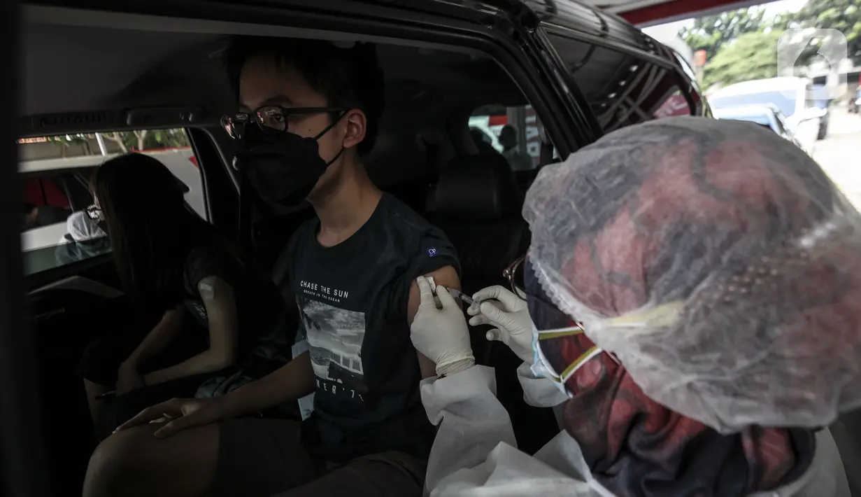 Warga menerima vaksinasi COVID-19 secara drive-thru di Jalan Duri Raya, Jakarta Barat, Kamis (8/7/2021). Yayasan Cinta anak Bangsa (YACB) Fondation menggelar vaksinasi COVID-19 secara drive-thru dengan menargetkan 800 hingga 1.000 warga ikut vaksinasi ini. (Liputan6.com/Johan Tallo)