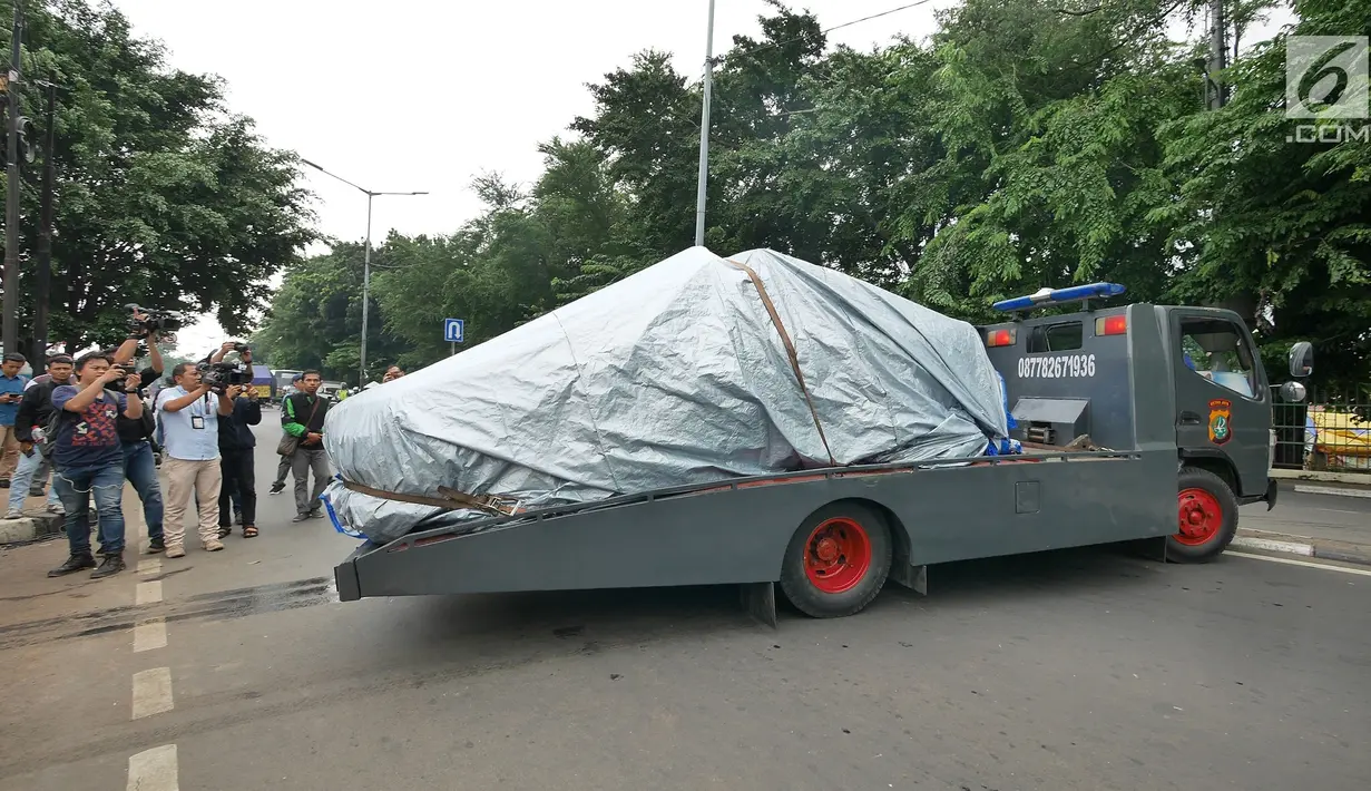 Petugas Ditlantas Polda Metro Jaya membawa mobil dinas polisi di Mapolsek Ciracas, Jakarta, Rabu (12/12). Pelayanan di Polsek Ciracas lumpuh pascapembakaran oleh massa tak dikenal. (Liputan6.com/Herman Zakharia)