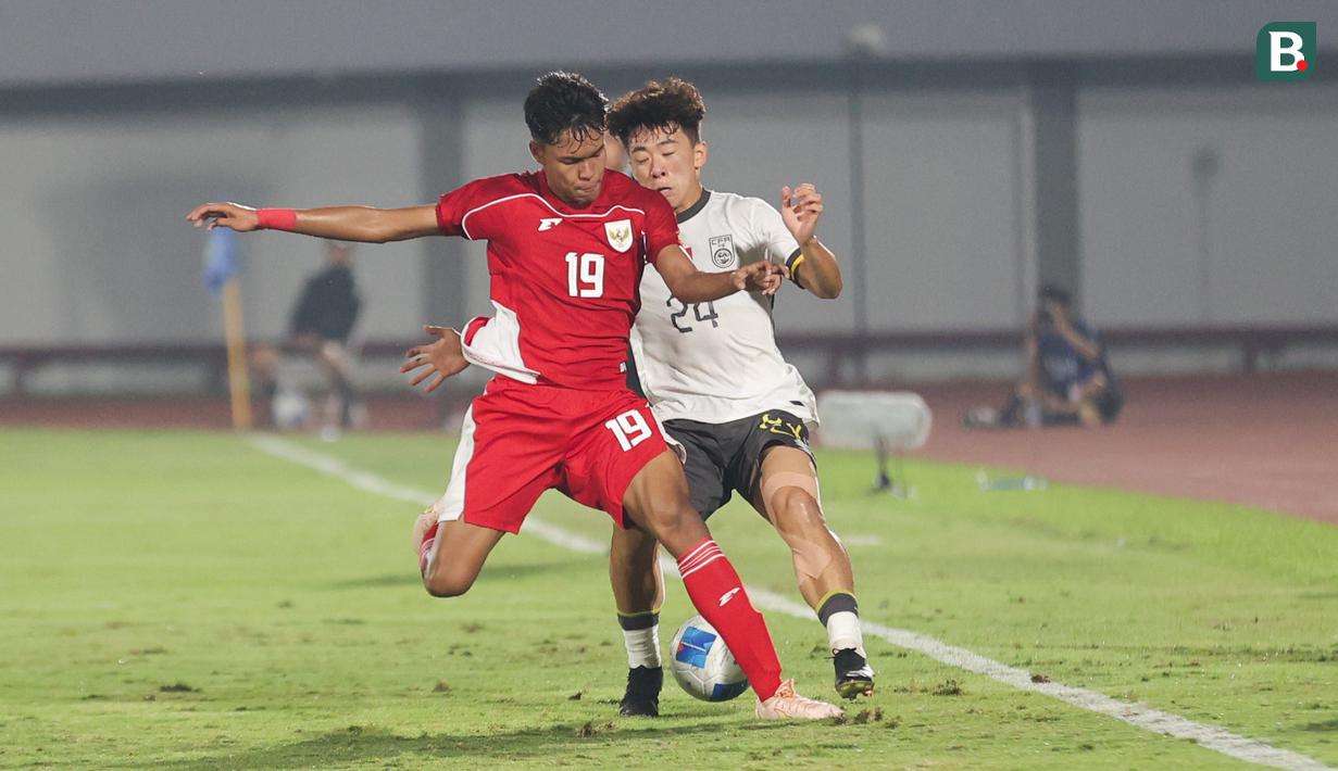 Pemain Timnas Indonesia U-17, Sean Rahman berduel dengan pemain China U-17, Kuang Zholei dalam pertandingan uji coba internasional di Indomilk Arena, Tangerang, pada Rabu (11/2/2026) malam WIB. (Bola.com/Abdul Aziz)