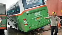 Bus Mayasari Bakti jurusan Pulo Gadung - UKI tersangkut pembatas Busway di jalan Perintis Kemerdekaan, Jaktim, Sabtu (23/1) akibat menghindari truk saat hujan deras. (Antara)