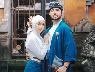 Kehidupan rumah tangga pasangan selebriti ini memang jauh dari sorotan publik. Sudah 7 tahun hidup bersama, Aryani Fitriana dan Donny Michael memang selalu romantis. Kali ini tampil kompak mengenakan baju adat Bali bernuansa biru dan putih. (Liputan6.com/IG/@aryanifitriana24)