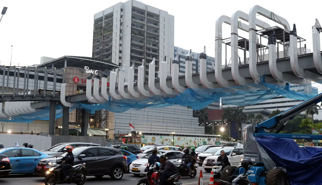 Pengendara melintas di bawah JPO Ratu Plaza di Jalan Jenderal Sudirman, Jakarta, Selasa (11/12). JPO Ratu Plaza merupakan 1 dari 12 JPO di sepanjang jalan Jend Sudirman - MH Thamrin yang masuk dalam proses revitalisasi. (Liputan6.com/Helmi Fithriansyah)