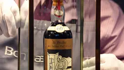 Porter Bonhams menunjukkan botol wiski Macallan Valerio Adamai 1926 pada lelang di Edinburgh, Rabu (3/10). Salah satu wiski paling dicari di dunia ini terjual setelah kolektor pribadi dari Asia memasukkan penawaran melalui telepon. (AFP/Andy Buchanan)