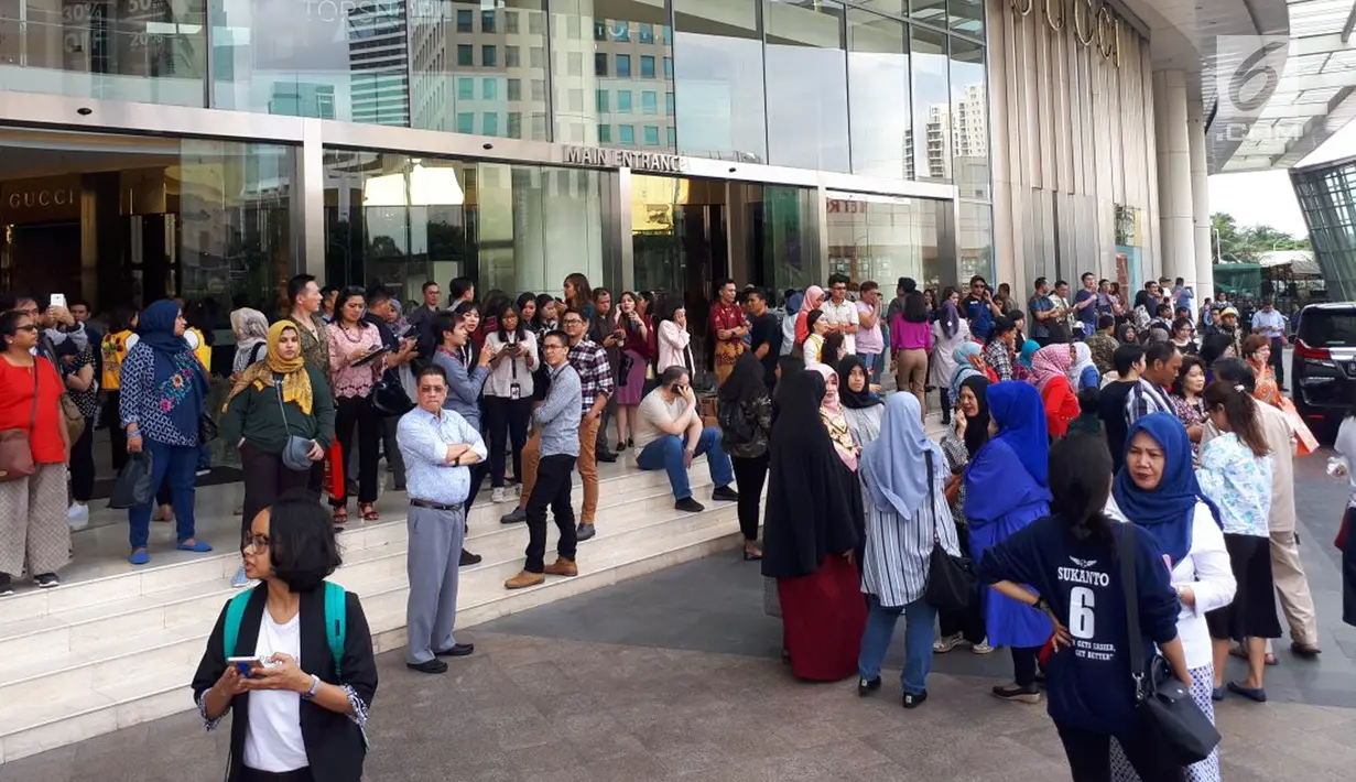 Pengunjung dan karyawan berhamburan keluar dan berkumpul di lobi pusat perbelanjaan Senayan City, Jakarta, Selasa (23/1).  Mereka panik setelah terjadi gempa berkekuatan 6,4 skala Richter yang berpusat di Lebak, Banten. (Liputan6.com/Fery Pradolo)
