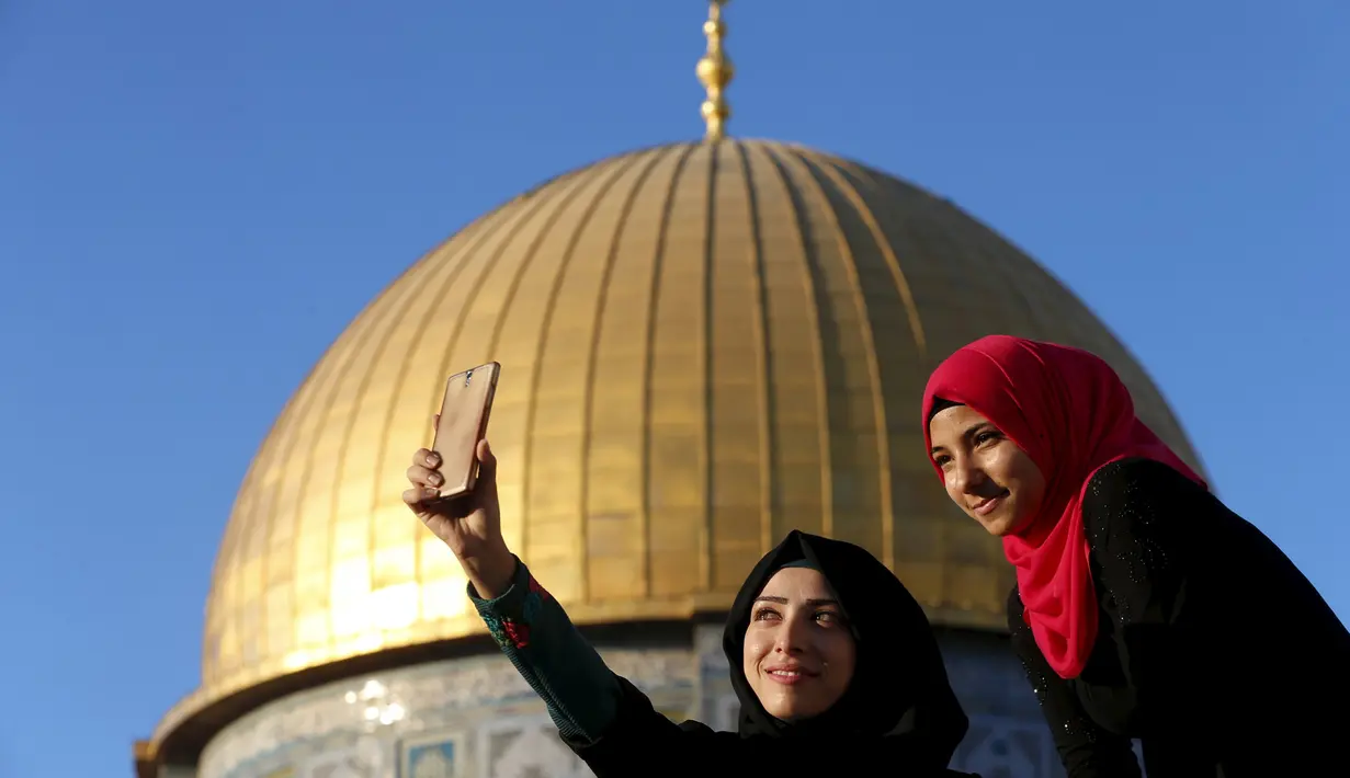 Salma Salame (kiri) dari kota Arab berfoto selfie dengan temannya di depan kubah Ash-Shakhrah di area Masjid Al-Aqsa, Yerusalem, 29 Juni 2015. (REUTERS/Ammar Awad)