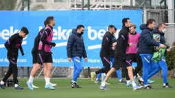 Pelatih Barcelona Xavi (tengah) dan para pemainnya mengambil bagian dalam sesi latihan di Barcelona pada 16 Februari 2022. Barcelona bakal meladeni Napoli pada leg pertama play-off babak gugur Liga Europa 2021/22 di Camp Nou, Jumat 18 Februari 2022. (LLUIS GENE / AFP)