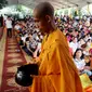 Seorang biksu berjalan di depan umat Buddha yang merayakan Hari Raya Waisak 2562 BE/2018 di Wihara Ekayana Arama, Jakarta Barat, Selasa (29/5). Puja Bakti Massal Waisak 2562 BE diikuti oleh ribuan umat Buddha. (Liputan6.com/JohanTallo)