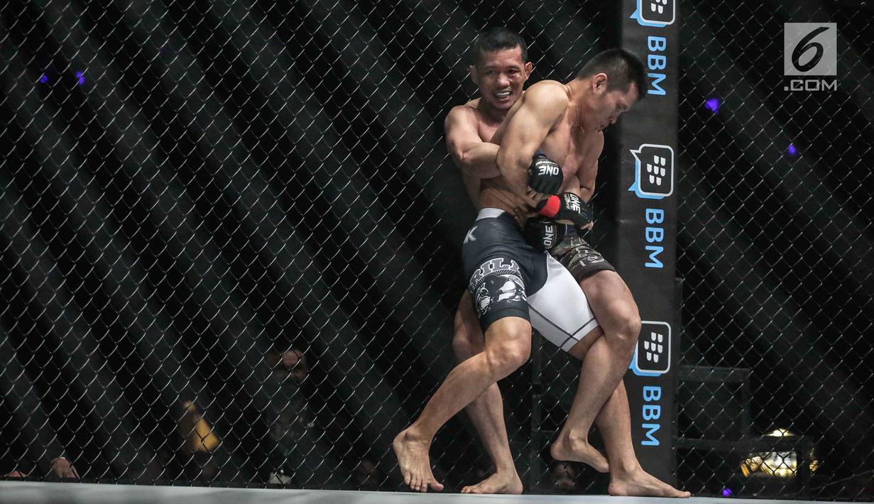 Dua petarung Indonesia Yohan Mulia Legowo berusaha mendekap petarung Victorio Senduk pada laga One Championship di Jakarta, Sabtu (20/1). Pada laga tersebut Victorio Senduk menang atas Yohan Mulia. (Liputan6.com/Faizal Fanani)