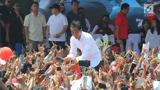 Capres 01 Joko Widodo menyapa pendukungnya saat kampanye terbuka di Kabupaten Cirebon, Jumat (5/4). Jokowi mengajak masyarakat Cirebon, untuk datang ke TPS dan meminta masyarakat untuk mencoblos surat suara yang fotonya memakai baju putih. (Liputan6 com/Angga Yuniar)