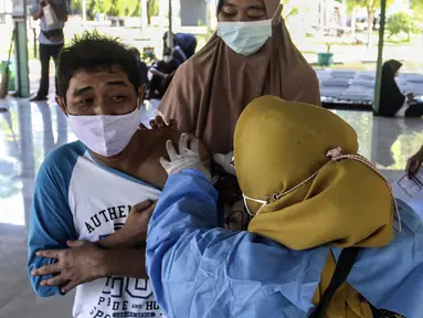 Warga menerima vaksin booster COVID-19 di Taman Pemuda Pratama, Depok, Jawa Barat, Kamis (7/4/2022). Presiden Joko Widodo telah mempersilakan masyarakat untuk mudik pada Lebaran 2022. (Liputan6.com/Johan Tallo)