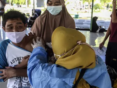 Warga menerima vaksin booster COVID-19 di Taman Pemuda Pratama, Depok, Jawa Barat, Kamis (7/4/2022). Presiden Joko Widodo telah mempersilakan masyarakat untuk mudik pada Lebaran 2022. (Liputan6.com/Johan Tallo)
