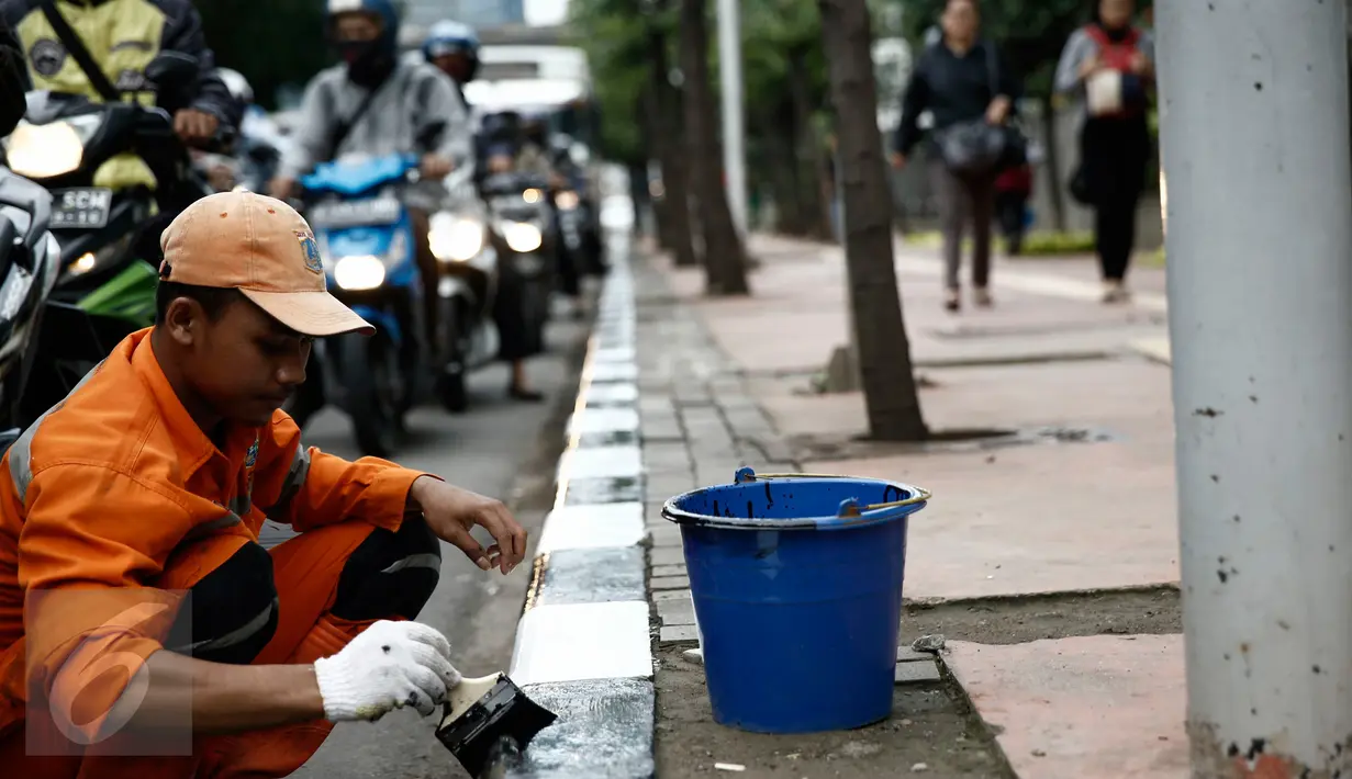 Petugas dari Kelurahan Karet Semanggi mengecat trotoar di kawasan Jalan Semanggi, Jakarta, Selasa (1/3/2016). Trotoar itu dipercantik dengan dicat ulang oleh Petugas Prasarana Sarana Umum (PPSU). (Liputan6.com/Faizal Fanani)