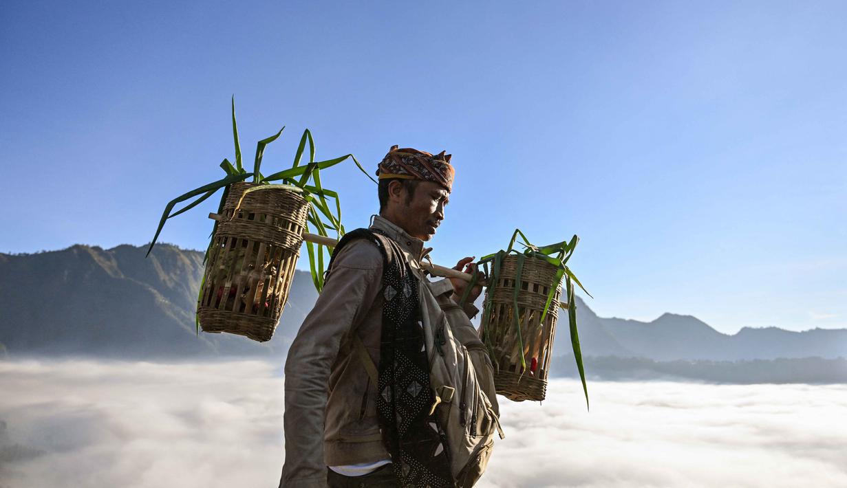 Warga suku Tengger mendaki gunung berapi aktif Bromo untuk mempersembahkan sesaji berupa beras, buah-buahan, ternak, dan barang-barang lainnya sebagai bagian dari festival Yadnya Kasada di dekat Probolinggo, Jawa Timur, Senin 1 Juni 2026. (JUNI KRISWANTO/AFP)