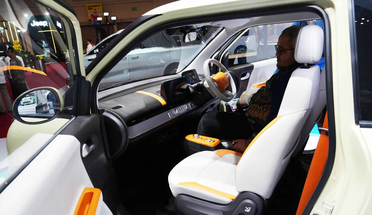 Bertempat di International Convention Exhibition (ICE) BSD, Tangerang, Banten, GJAW 2025 akan berlangsung hingga 30 November 2025. Tampak dalam foto, seorang pengunjung memeriksa interior kendaraan listrik Lumin buatan produsen mobil Tiongkok, Changan, selama Gaikindo Jakarta Auto Week (GJAW) 2025 di Tangerang, Banten, Jumat 21 November 2025. (AP Photo/Tatan Syuflana)