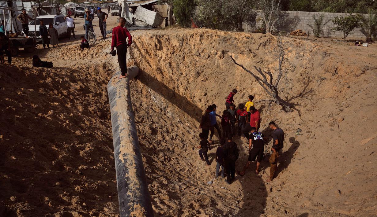 Warga Palestina memeriksa kerusakan akibat serangan Israel di Khan Younis, Jalur Gaza selatan, Selasa 19 Mei 2026. (AP Photo/Abdel Kareem Hana)