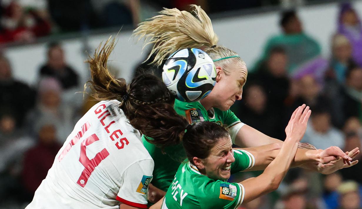 Pemain Irlandia, Niamh Fahey (kanan bawah dan Louise Quinn (kanan atas) berebut bola dengan pemain Kanada Vanessa Gilles pada laga Grup B Piala Dunia Wanita 2023 di Perth Rectangular Stadium, Perth, Australia, 26 Juli 2023. (AFP/Colin Murty)