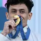 Atlet panjat tebing Indonesia, Veddriq Leonardo mencium medali emasnya saat di atas podium cabang olahraga panjat tebing nomor speed Olimpiade Paris 2024 di Le Bourget Sport Climbing Venue, Paris, Prancis, Kamis (08/08/2024). (AFP/Jonathan Nackstrand)