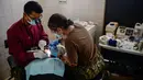 Seorang pasien mendapat tindakan medis di atas kapal rumah sakit USNS Comfort yang berlabuh di wilayah Piura, Peru, 5 November 2018. Kapal rumah sakit ini dilengkapi alat medis paling canggih, dokter dan perawat berlisensi. (ERNESTO BENAVIDES / AFP)