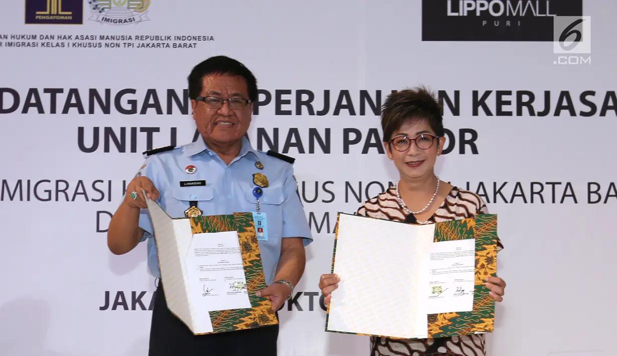 Kepala Kantor Imigrasi Kelas I Khusus Jakarta Barat, Lumaksono bersalaman dengan Direktur Lippo Mall Puri, Rita Yovita usai menandatangani MOU kerjasama pembukaan gerai layanan paspor di Lippo Mall Puri, Jakarta, Selasa (16/10). (Merdeka.com/Arie Basuki)