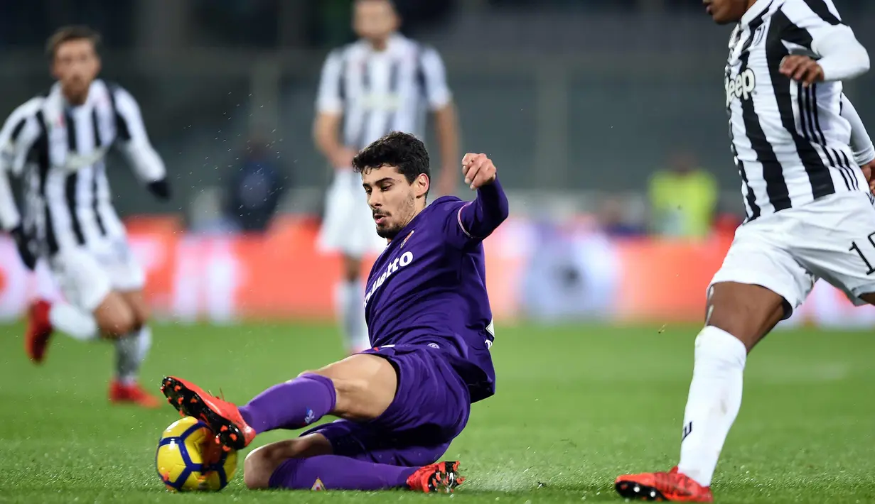 Pemain Fiorentina Gil Dias berusaha merebut bola dari kejaran bek Juventus, Alex Sandro saat bertanding pada lanjutan Liga Serie A Italia di stadion Atemio Franchi, Florence (9/2). Juventus menang 2-0. (AFP Photo/Filippo Monteforte)