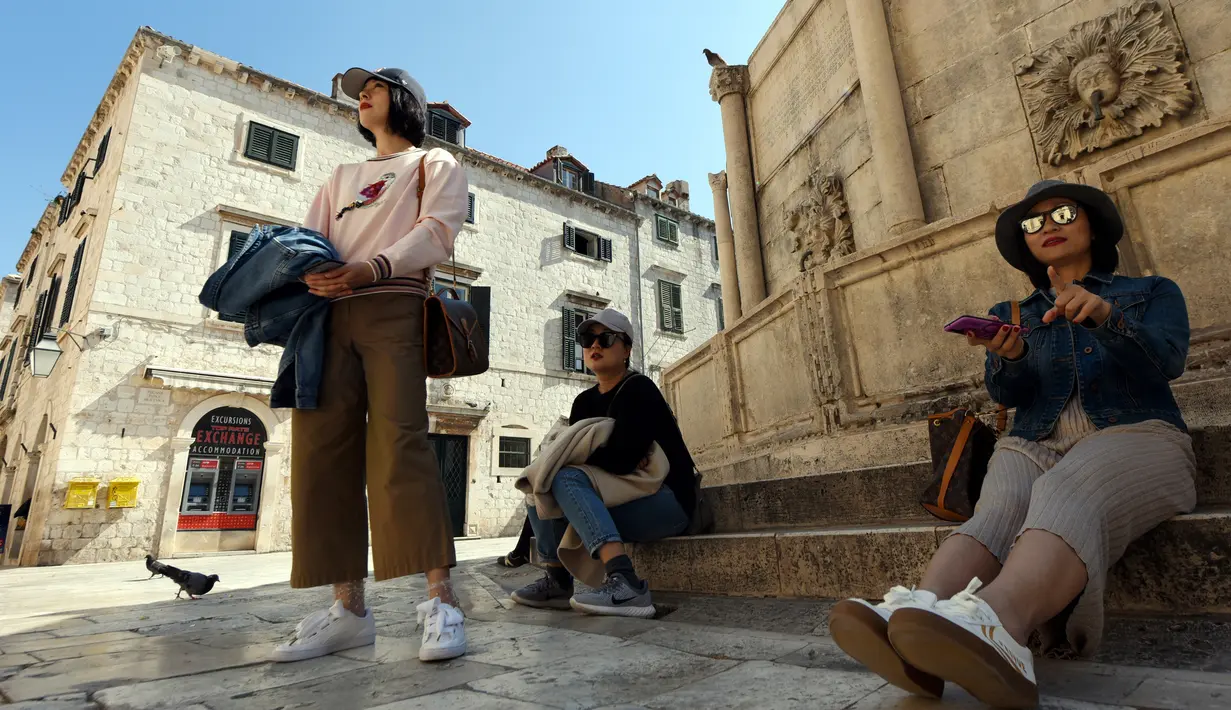 Wisatawan beristirahat di Stradun, jalan utama kota tua Dubrovnik di Kroasia pada 28 Maret 2019. Stradun, atau lebih dikenal dengan Plaka menjadi daya tarik utama para pengunjung yang hilir mudik menikmati suasana kota. (Denis LOVROVIC / AFP)