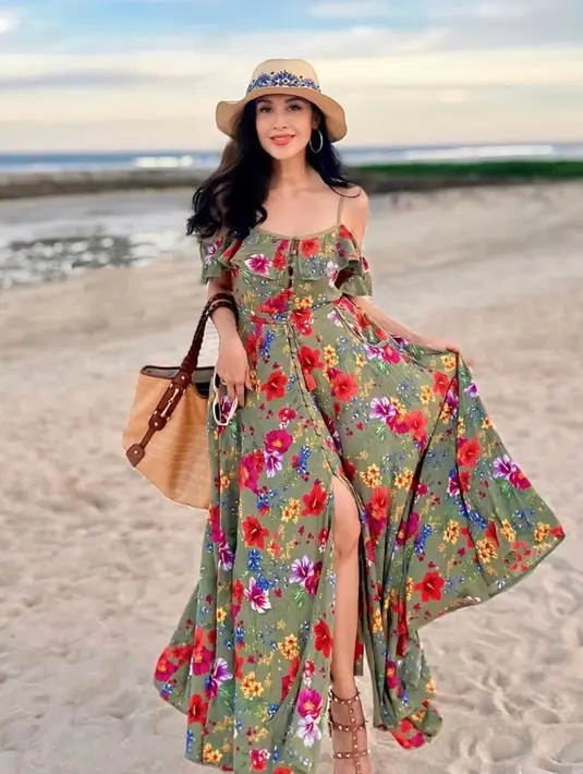 Diah Permatasari juga liburan ke Bali bersama putranya. Di pantai ia mengenakan long dress floral spaghetti strap. Membawa tote bag coklat dan mengenakan topi pantai. [@dps_diahpermatasari]