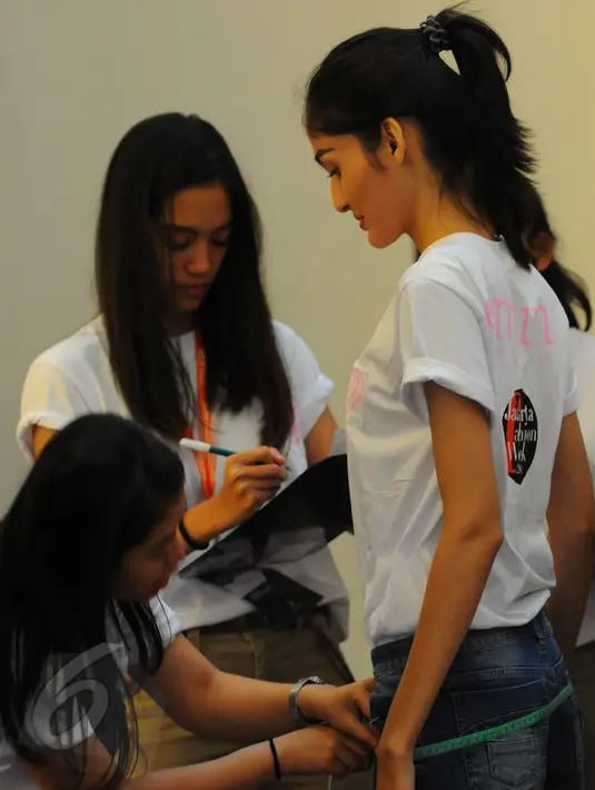 Panitia melakukan pengukuran pada salah satu peserta audisi model catwalk Jakarta Fashion Week(JFW) 2015, Atrium Senayan City Mall, Jakarta, Rabu, (3/6/2015). JFW menggelar audisi para model catwalk untuk event JFW 2015. (Liputan6.com/Faisal R Syam)