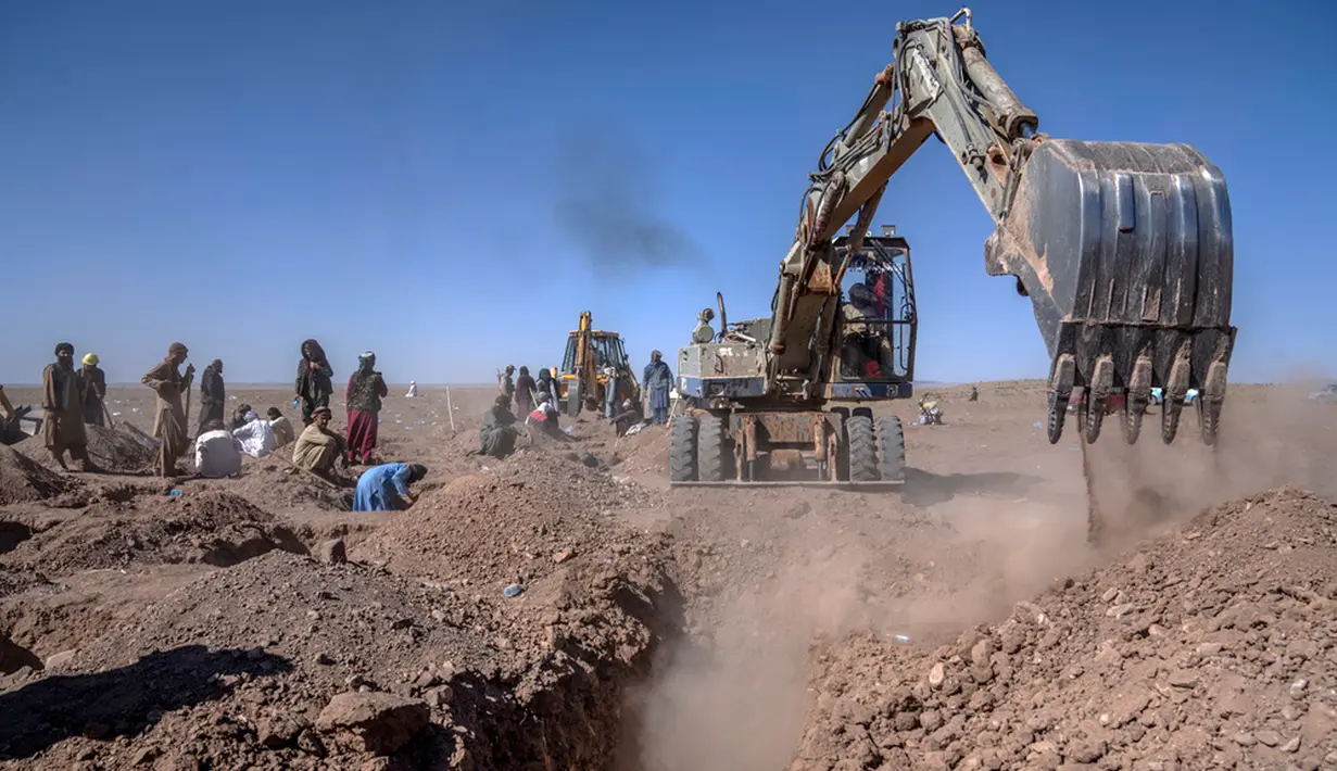 Warga Afghanistan menguburkan ratusan orang secara massal yang tewas dalam gempa bumi di sebuah tempat pemakaman di luar sebuah desa di Distrik Zenda Jan. (AP Photo/Ebrahim Noroozi)