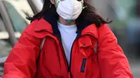 Seorang wanita mengenakan masker bersepeda di Milan, Italia (24/2/2020). Kepala Departemen Perlindungan Sipil sekaligus Komisaris Luar Biasa untuk Darurat Coronavirus, Angelo Borrelli mengatakan enam orang meninggal dan 222 lainnya teruji positif infeksi COVID-19 di Italia. (Xinhua/Daniele Mascolo)