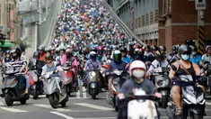 Pengendara sepeda motor melintasi Jembatan Taipei pada jam sibuk pagi hari, China (21/5). Sebelumnya telah beredar sebuah video mengejutkan mengenai kondisi sebuah jalan yang dipenuhi oleh antrean motor. (AFP Photo/Chris Stowers)