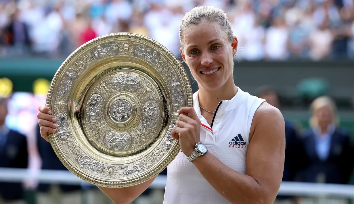 Petenis Jerman, Angelique Kerber tersenyum saat berpose dengan trofi usai mengalahkan petenis AS, Serena Williams pada final tunggal putri kejuaraan Tenis Wimbledon 2018 di London, (14/7). Kerber menang atas Williams 6-3,6-3. (AP Photo/Jonathan Brady)