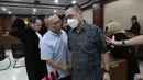 Dalam dakwaannya, jaksa mengatakan perbuatan para terdakwa terkait tata kelola minyak mentah telah menyebabkan kerugian negara sebesar Rp 285 triliun. Tampak dalam foto, terdakwa kasus dugaan korupsi tata kelola minyak mentah, Hanung Budya Yuktyanta (kedua kiri) berbincang dengan Martin Haendra Nata usai mengikuti sidang pembacaan tuntutan di Pengadilan Tindak Pidana Korusi (Tipikor), Jakarta, Kamis (23/4/2026). (Kapanlagi.com/Budy Santoso)