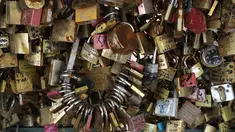Gembok cinta yang sebelumnya terpasang di Jembatan Pont des Art saat dilelang oleh Ville de Paris, Prancis, Rabu (3/5). Ratusan gembok cinta itu akhirnya dilelang dan hasil dari penjualan akan disumbangkan ke pengungsi di Paris. (Jacques DEMARTHON/AFP)
