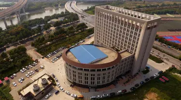 Pandangan udara menunjukkan sebuah gedung universitas di Zhengzhou, Provinsi Henan, China, (21/9). Gedung tersebut ketika dilihat dari udara memeliki bentuk mirip dengan kloset duduk yang menjadi bahan candaan oleh warganet. (AFP Photo/Str/China Out)