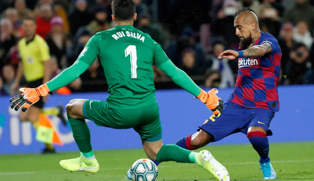 Gelandang senior Barcelona, Arturo Vidal berebut bola dengan kiper Granada, Rui Silva pada lanjutan pertandingan La Liga Spanyol di Camp Nou, Minggu (19/1/2020). Barcelona sukses meraih kemenangan atas tamunya Granada dengan skor tipis 1-0. (AP/Joan Monfort)