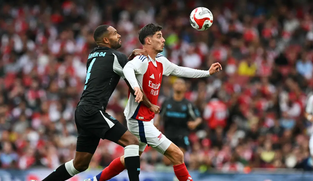 Gelandang Arsenal Kai Havertz berebut bola dengan bek Bayer Leverkusen Odilon Kossounou dalam duel pramusim 2024 di Emirates Stadium, Kamis (8/8/2024) dini hari WIB. (Glyn KIRK / AFP)