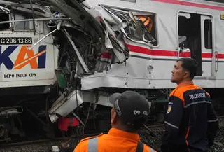 Para pekerja memeriksa kondisi lokomotif Kereta Api Jarak Jauh (KAJJ) Argo Bromo Anggrek dan salah satu gerbong Kereta Rel Listrik (KRL) Commuter Line yang mengalami kecelakaan di Stasiun Bekasi Timur, Bekasi, Jawa Barat, Selasa 28 April 2026. (AP Photo/Tatan Syuflana)