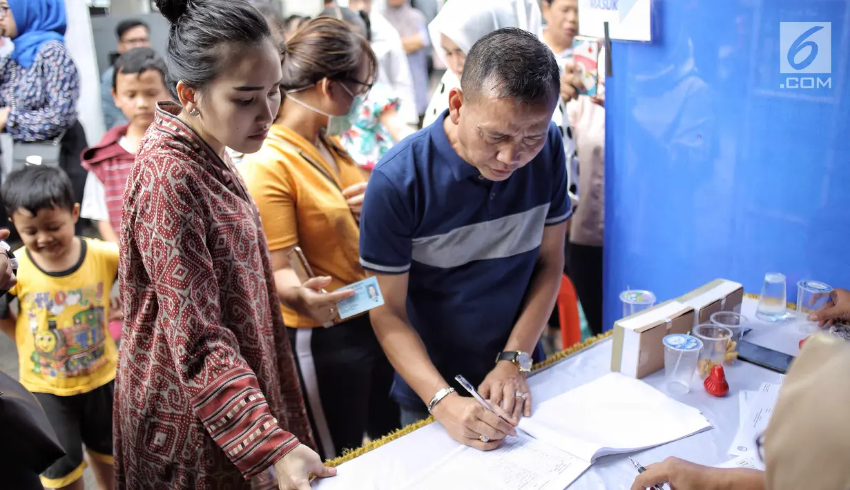 Pendangdut Ayu Ting Ting bersama sang ayah, Abdul Rozak mendaftar kehadirannya pada Pilkada Serentak 2018 di  TPS 5, Sukma Jaya, Depok, Rabu (27/6). Kota Depok bersiap menentukan gubernur Jawa Barat untuk 5 tahun mendatang. (Liputan6.com/Faizal Fanani)