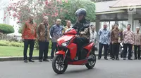 Presiden Joko Widodo (Jokowi) menjajal sepeda motor listrik Gesits di Istana Merdeka, Jakarta, Rabu (7/11). Mengenakan helm buatan Gesits, Jokowi menyusuri aspal di halaman Istana Merdeka menuju Istana Negara. (Liputan6.com/Angga Yuniar)