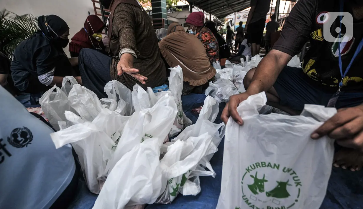 Panitia mengemas daging hewan kurban saat perayaan Hari Raya Idul Adha 1442 H di Musala Nurul Huda, Jakarta, Selasa (20/7/2021). Panitia diwajibkan mengenakan masker dan menerapkan protokol kesehatan guna mencegah penyebaran COVID-19. (merdeka.com/Iqbal S. Nugroho)