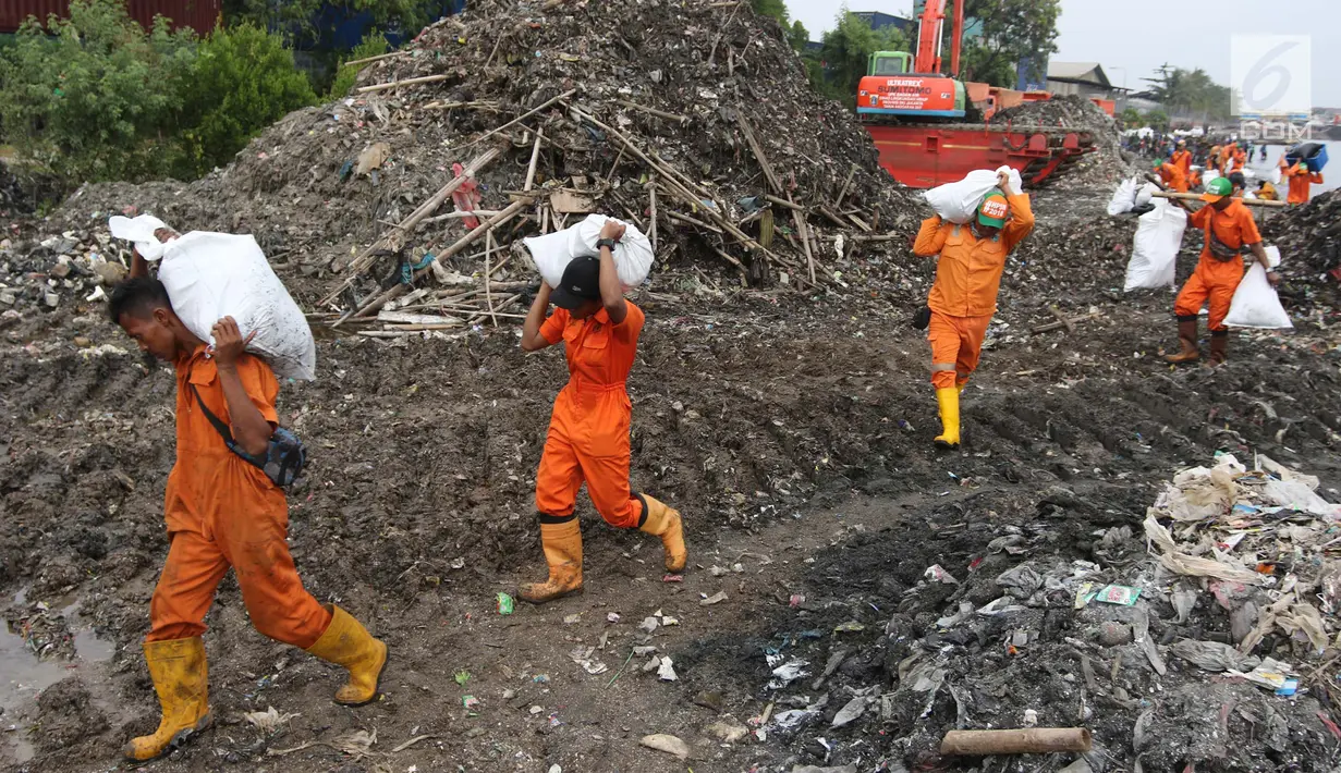 Petugas mengangkat karung yang berisi sampah saat mengikuti Gerebek Sampah di Pesisir Teluk Jakarta, Cilincing, Jakarta Utara, Minggu (15/4). (Liputan6.com/Arya Manggala)