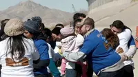 Suasana haru saat warga Meksiko bertemu keluarga dan kerabat mereka di perbatasan Meksiko-AS di Ciudad Juarez, Meksiko (28/1). Dengan waktu yang singkat, akhirnya mereka dapat melepas rindu setelah lama berpisah. (AP Photo/Christian Torres)