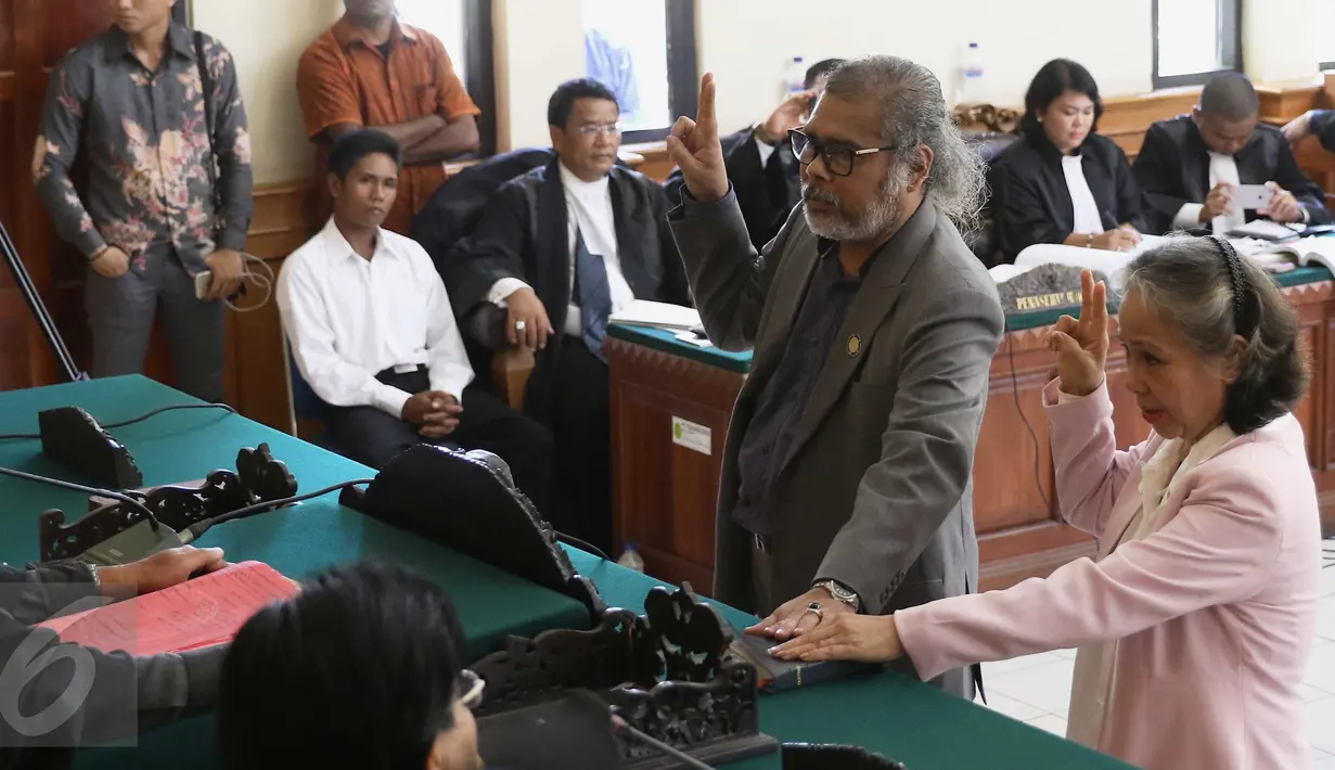 Terdakwa Margriet Megawe (kanan) dan Ketua KPAI Arist Merdeka Sirait (kiri) saat mengucap sumpah dalam persidangan kasus Angeline, Pengadilan Negeri Denpasar, (12/1). Jaksa menghadirkan Arist Merdeka untuk memberikan kesaksian. (Liputan6.com/Angga Yuniar)