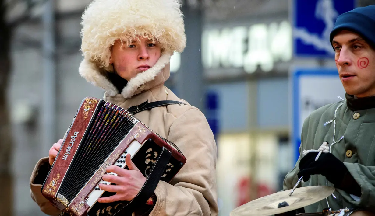Seniman jalanan memainkan musiknya saat tampil dalam festival yang menandai Tahun Baru dan Natal di Moskow, Rusia (2/1). (AFP Photo/Mladen Antonov)