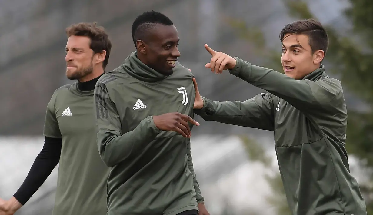 Penyerang Juventus, Paulo Dybala (kanan) berbincang dengan rekannya Blaise Matuidi saat sesi latihan di pusat pelatihan Juventus di Vinovo (2/4). Juventus akan bertanding melawan Real Madrid. (AFP Photo/Marco Bertorello)